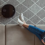 woman-relaxing-while-robot-vacuum-cleaner-operates
