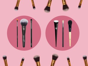 A collection of makeup brushes from the likes of Bobbie Brown, Kat Von D, MAC and more against a pink background