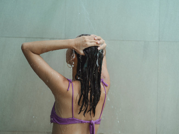 Woman washing her hair using a shampoo bar.