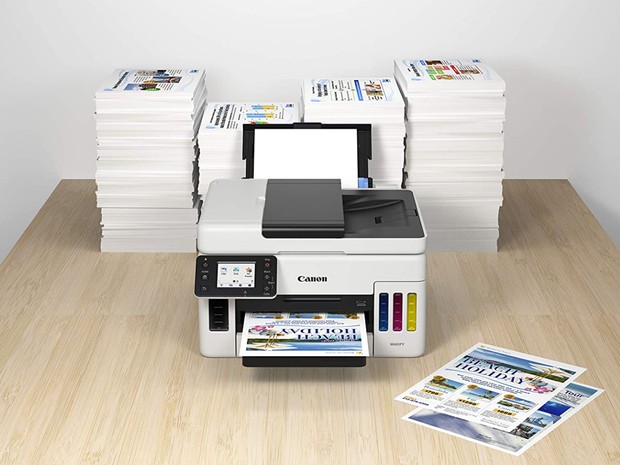 canon printer with stacks of printed paper surrounding