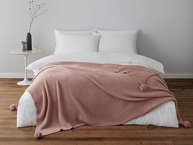 Dunelm Pom Pom Blush Throw can be used to promote hygge.