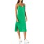 Green midi slip dress worn by model with white chunky trainers.